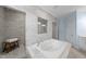 Elegant bathroom featuring a large soaking tub and marble tile throughout at 1141 Barley Stone Way, Raleigh, NC 27603