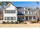 Two-story white brick home with black shutters, a porch, and manicured landscaping at 1141 Barley Stone Way, Raleigh, NC 27603