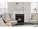 Cozy fireplace with white mantle and hearth, flanked by comfortable chairs at 1141 Barley Stone Way, Raleigh, NC 27603