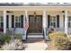 Inviting covered porch with columns, ceiling fans, and double wood doors at 1141 Barley Stone Way, Raleigh, NC 27603