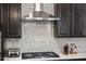 Modern kitchen features stainless steel range hood, marble backsplash, and dark cabinets at 1141 Barley Stone Way, Raleigh, NC 27603