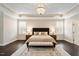 Elegant main bedroom featuring a tray ceiling, chandelier, and windows with white shutters at 1141 Barley Stone Way, Raleigh, NC 27603