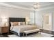 Luxurious main bedroom featuring a chandelier, tray ceiling, and adjoining bathroom at 1141 Barley Stone Way, Raleigh, NC 27603