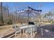 Outdoor dining area with a white table, chairs, grill, and umbrella on a brick patio at 1141 Barley Stone Way, Raleigh, NC 27603