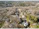 An aerial view showcases a single story brick home nestled among mature trees in a established neighborhood at 1205 Glen Eden Dr, Raleigh, NC 27612