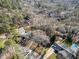 An aerial view highlights a single story brick home nestled among mature trees in a established neighborhood at 1205 Glen Eden Dr, Raleigh, NC 27612