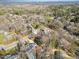 An aerial view showcases a single story brick home nestled among mature trees in a established neighborhood at 1205 Glen Eden Dr, Raleigh, NC 27612