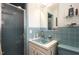 Retro bathroom featuring blue tile, shower, and vanity, blending vintage charm with functionality at 1205 Glen Eden Dr, Raleigh, NC 27612