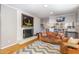 Cozy living room with painted brick fireplace, comfortable leather sofa, and open layout to the kitchen at 1205 Glen Eden Dr, Raleigh, NC 27612