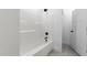 All-white shower and bathroom combination, featuring black fixtures and a tile floor at 125 Sue-Kim Dr, Youngsville, NC 27596