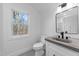 Modern bathroom featuring a gray concrete sink, black faucet, and natural light from the window at 125 Sue-Kim Dr, Youngsville, NC 27596