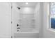 Bright bathroom with a shower-tub combo, black fixtures, and a window for natural light at 125 Sue-Kim Dr, Youngsville, NC 27596