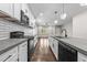 Modern kitchen with white cabinets, concrete countertops, subway tile backsplash, and an open layout to the living room at 125 Sue-Kim Dr, Youngsville, NC 27596