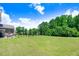 Expansive backyard with lush greenery, mature trees, and a tranquil waterfront view at 130 Daniel Farm Dr, Benson, NC 27504