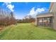 Backyard of the home with a large lawn, screened porch, and pond at 130 Daniel Farm Dr, Benson, NC 27504