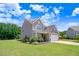 Side view of a well-maintained two-story home with a lush green lawn and manicured landscaping at 130 Daniel Farm Dr, Benson, NC 27504