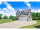 View of the tan two story house from an angle showing the driveway and landscaping at 130 Daniel Farm Dr, Benson, NC 27504