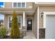Charming home entrance with black door, decorative wreath, stone accents, and manicured landscaping at 130 Daniel Farm Dr, Benson, NC 27504