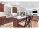 Open-concept kitchen featuring an island with seating, stainless steel sink, and natural light, seamlessly flowing into the living area at 130 Daniel Farm Dr, Benson, NC 27504
