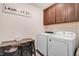 A laundry room with a washer, a dryer, and dark wood cabinets at 130 Daniel Farm Dr, Benson, NC 27504