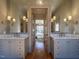 Elegant bathroom with dual sinks, marble countertops, stylish lighting, and a view into the main bedroom at 1324 Brooks Ave, Raleigh, NC 27607