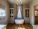 Luxurious bathroom with a standalone tub, natural light, elegant fixtures, and built-in cabinetry at 1324 Brooks Ave, Raleigh, NC 27607