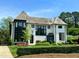 Stunning white brick home featuring black trim, gorgeous landscaping, and a meticulously maintained lawn at 1324 Brooks Ave, Raleigh, NC 27607