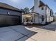 Beautiful home with a black garage door, white siding, and a cozy outdoor seating area on a covered patio at 1324 Brooks Ave, Raleigh, NC 27607