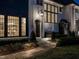 Elegant exterior of white brick home featuring a stone walkway and lush landscaping at twilight at 1324 Brooks Ave, Raleigh, NC 27607