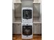 Convenient laundry area featuring a stacked washer and dryer unit and gray cabinets for storage at 1324 Brooks Ave, Raleigh, NC 27607