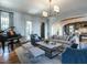 Open-concept living room featuring a piano, comfortable seating, and an arched entry to the dining area at 1324 Brooks Ave, Raleigh, NC 27607
