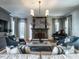 Cozy living room with a fireplace, piano, plush seating, and natural light from the nearby windows at 1324 Brooks Ave, Raleigh, NC 27607
