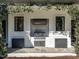 Outdoor kitchen with built-in grill, surrounded by black framed windows, and lush landscaping at 1324 Brooks Ave, Raleigh, NC 27607