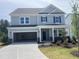 Two-story home with gray siding, a two car garage, manicured lawn, and a covered front porch at 250 Tidal Pool Way, Cary, NC 27519