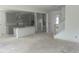 Spacious, unfinished kitchen featuring gray cabinets, an island, and view into the living area at 250 Tidal Pool Way, Cary, NC 27519