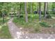 Serene backyard with a pea gravel path, fire pit, and shady trees for relaxation and entertainment at 326 W Bywood Dr, Durham, NC 27712