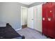 Bedroom features gray walls, red metal lockers, closet, and doorway into the hallway at 326 W Bywood Dr, Durham, NC 27712