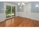 Dining room with hardwood floors, modern chandelier, and doors to the backyard at 326 W Bywood Dr, Durham, NC 27712