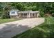 Inviting home with brick accents, a bright white porch and plenty of parking on the concrete driveway at 326 W Bywood Dr, Durham, NC 27712