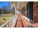 Charming front porch with brick flooring and white railing, perfect for enjoying the outdoors at 326 W Bywood Dr, Durham, NC 27712