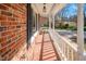 Inviting brick front porch with classic columns and tiled floor, perfect for enjoying outdoor relaxation at 326 W Bywood Dr, Durham, NC 27712