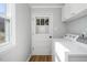 Bright laundry room with white cabinets, a window, and modern washer/dryer for convenience at 326 W Bywood Dr, Durham, NC 27712