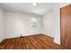 Hardwood floors and a simple bedroom with a window at 3817 Booker Ave, Durham, NC 27713