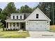 Two-story home with white siding, brown accents, and a two-car garage at 387 E Clydes Point Way, Wendell, NC 27591