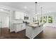 Stylish kitchen with white cabinets, granite countertops, a large island, and ample natural light at 387 E Clydes Point Way, Wendell, NC 27591