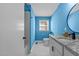 Stylish bathroom with blue walls, marble vanity and shower/tub combo at 420 Nelson St, Durham, NC 27707