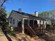 Rear exterior view of home with deck, patio, sunroom, and mature trees at 446 Crossvine Close, Pittsboro, NC 27312