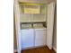 Bright laundry room with washer, dryer, and built-in shelving at 446 Crossvine Close, Pittsboro, NC 27312