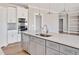 Modern kitchen with white cabinets, gray island, and quartz countertops at 7723 Barefoot Rd, Fuquay Varina, NC 27526