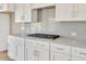 Modern kitchen with white cabinets and gas cooktop at 7723 Barefoot Rd, Fuquay Varina, NC 27526